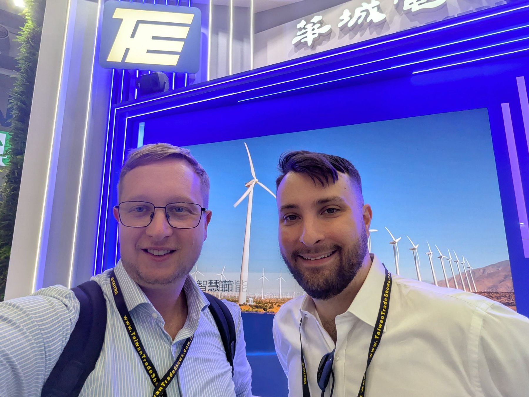 Two members of the Jinka team at Energy Taiwan, in front of a wind-energy display.